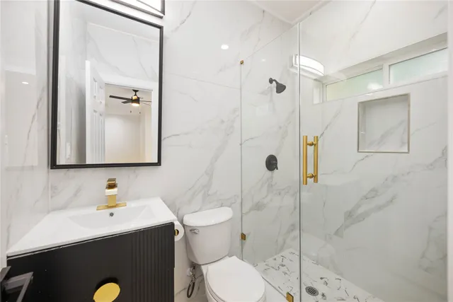 a bathroom with a sink a toilet and shower