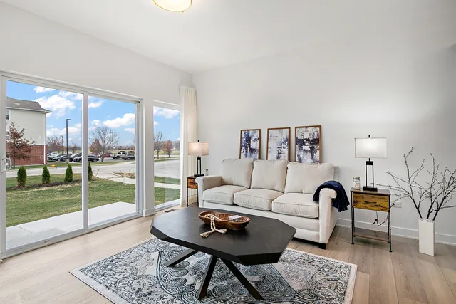 a living room with furniture and a floor to ceiling window