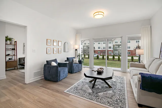 a living room with furniture and a floor to ceiling window