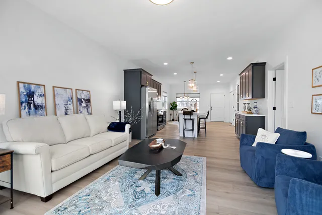 a living room with furniture kitchen view and a table