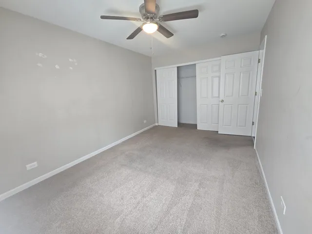 a view of an empty room and a ceiling fan
