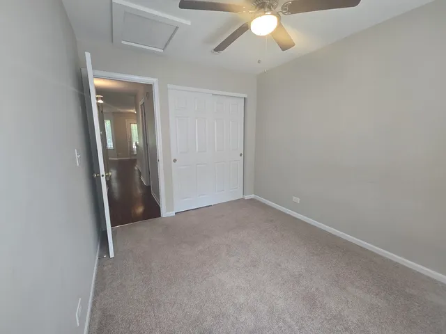 an empty room with a fan & a chandelier fan