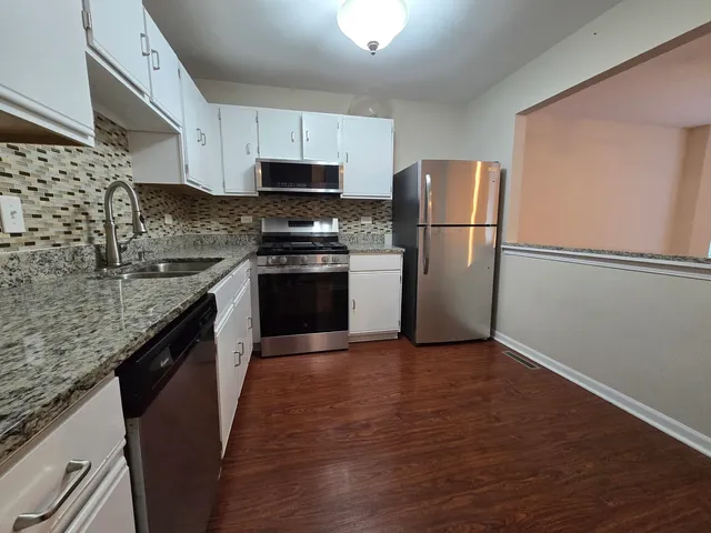a kitchen with stainless steel appliances granite countertop a refrigerator stove a sink and dishwasher