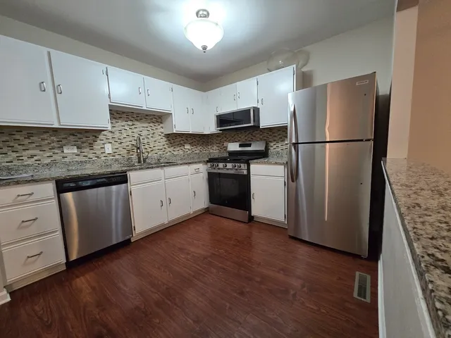 a kitchen with stainless steel appliances granite countertop a refrigerator sink and cabinets