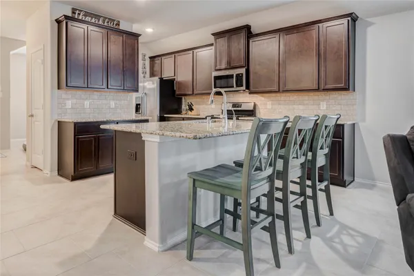 a kitchen with kitchen island granite countertop wooden cabinets and stainless steel appliances