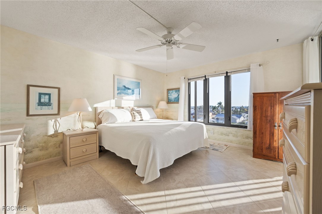 4260 Southeast 20th Place, Unit 502 Cape Coral, FL 33904 - Photo 17 of 49 a spacious bedroom with a large bed and a chandelier