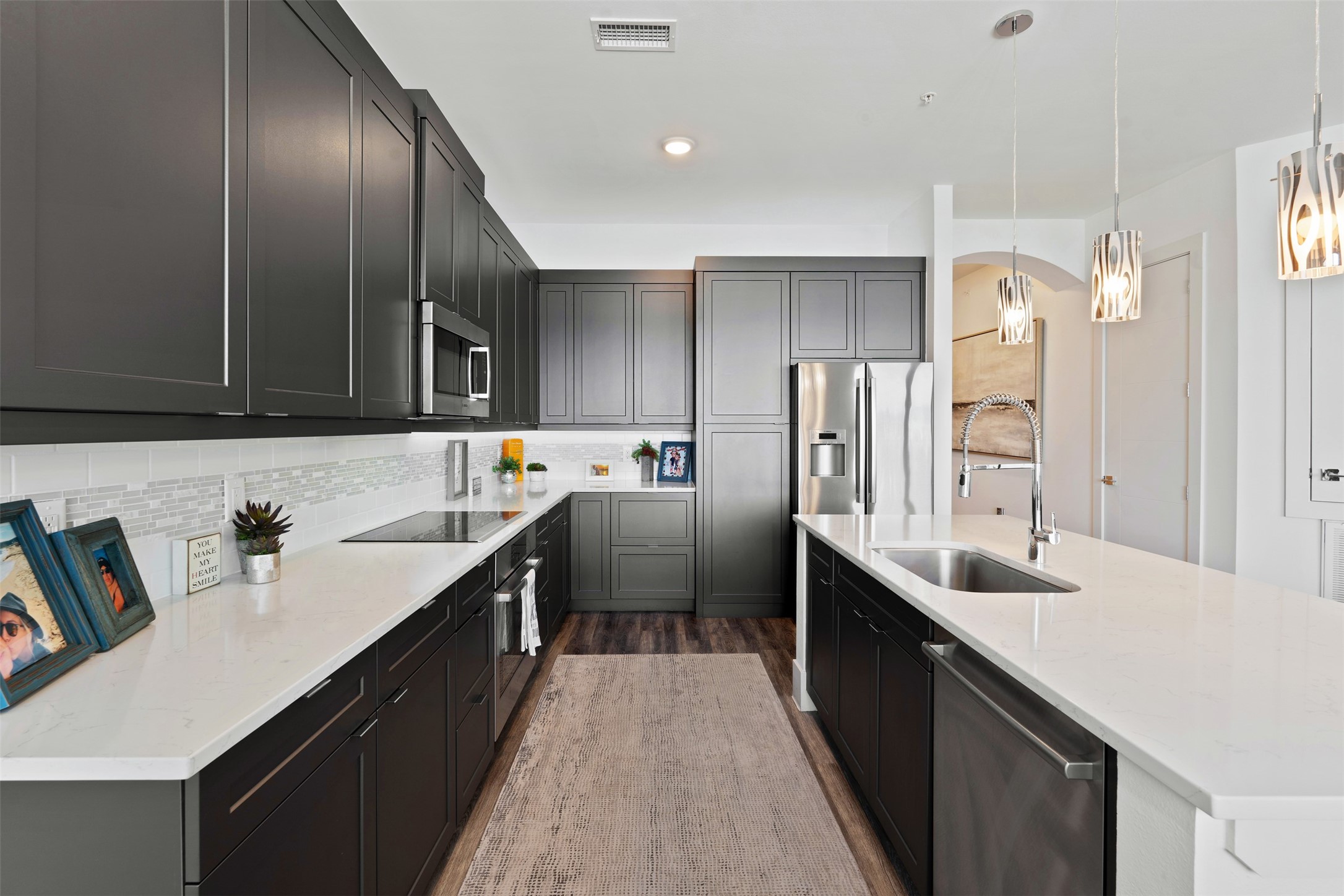 199 Waterpoint Court, Unit 208 Conroe, TX 77304 - Photo 16 of 39 a kitchen with stainless steel appliances a sink stove top oven and cabinets