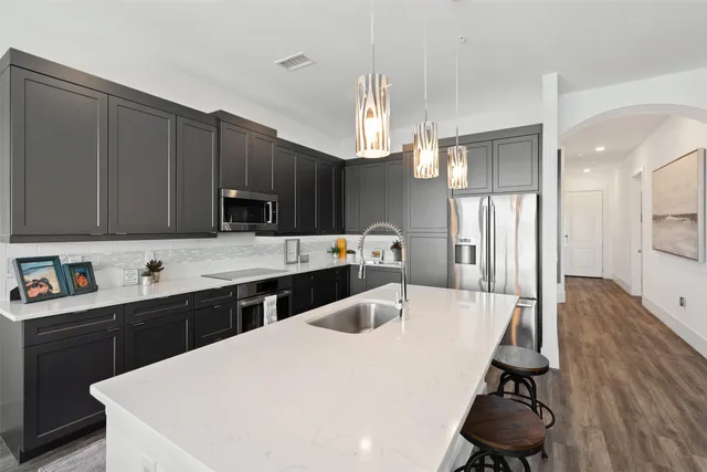 a kitchen with kitchen island a sink appliances and cabinets