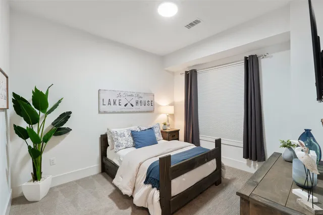 a bedroom with a large bed and a potted plant