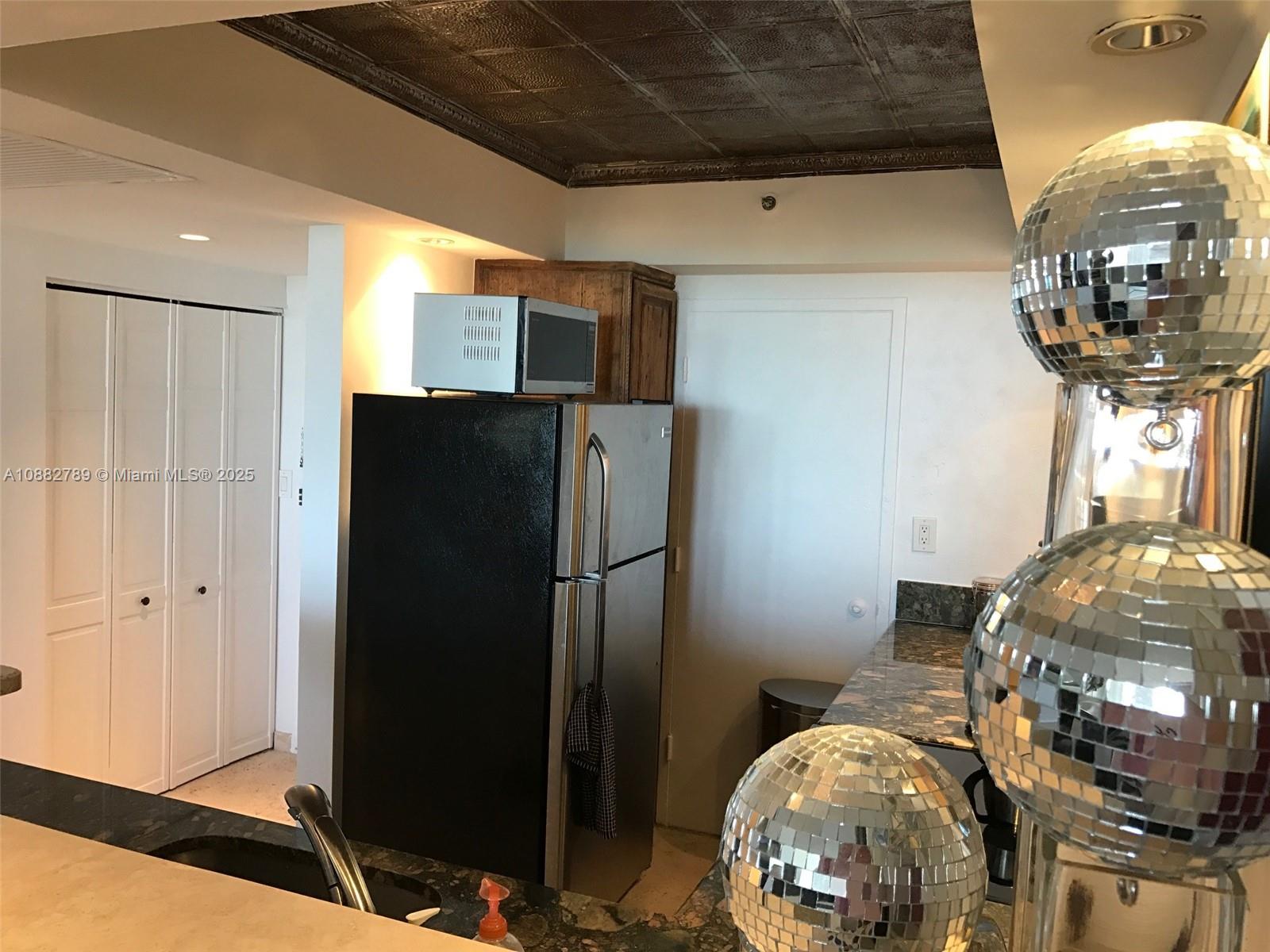 100 Lincoln Road, Unit 644 Miami Beach, FL 33139 - Photo 24 of 46 a kitchen with stainless steel appliances wooden floor and chandelier