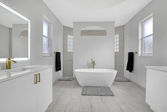 a spacious bathroom with a sink a mirror and a bathtub