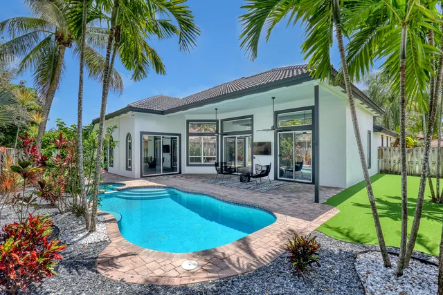 a view of a house with swimming pool and sitting area