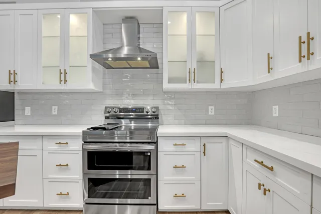 a kitchen with white cabinets and a stove with a sink