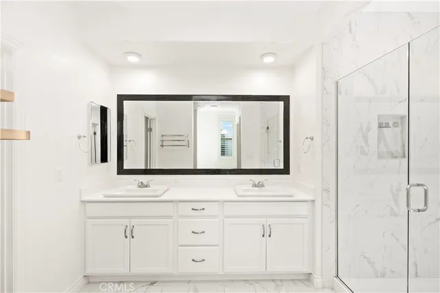 a bathroom with a double vanity sink mirror double and shower