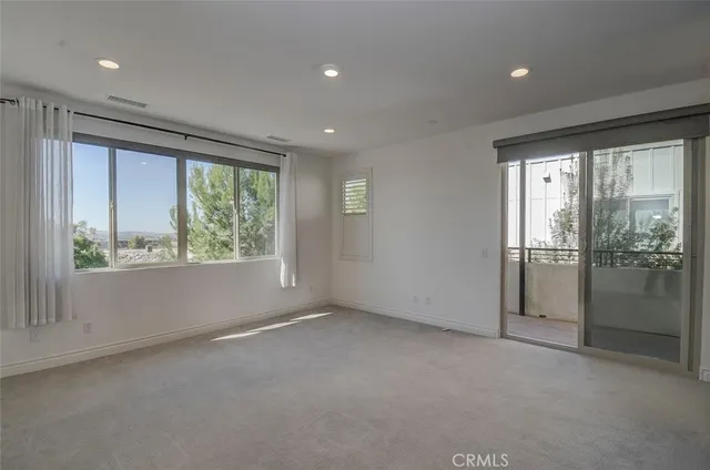 an empty room with windows and closet