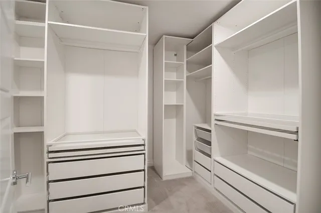 a view of walk in closet with empty racks