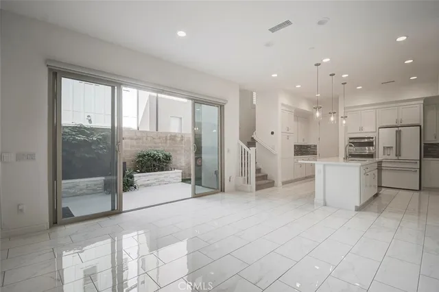 a open kitchen with white cabinets and stainless steel appliances
