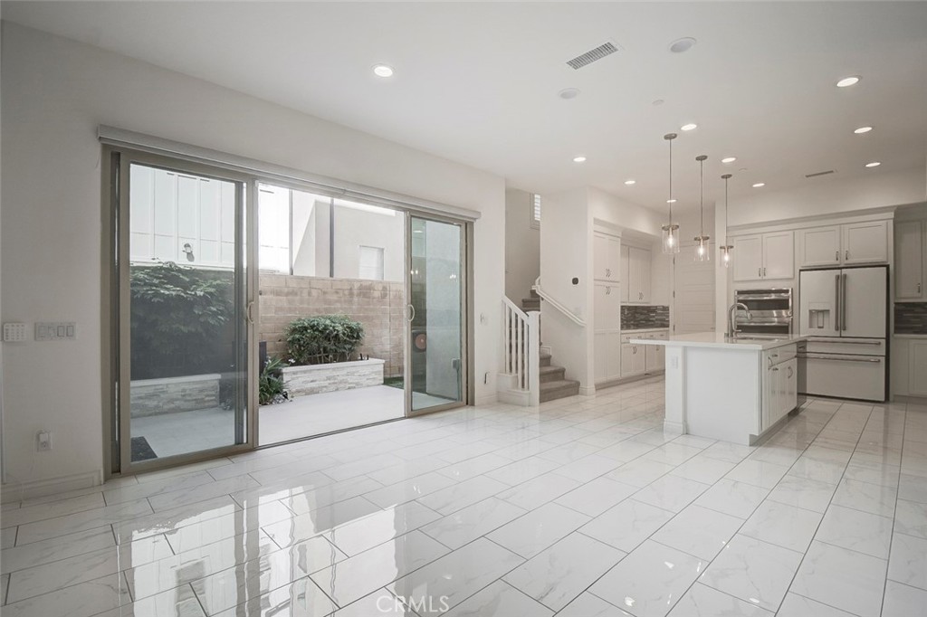 148 Spectacle Irvine, CA 92618 - Photo 4 of 47 a open kitchen with white cabinets and stainless steel appliances