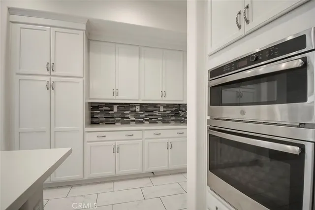 a kitchen with white cabinets and appliances