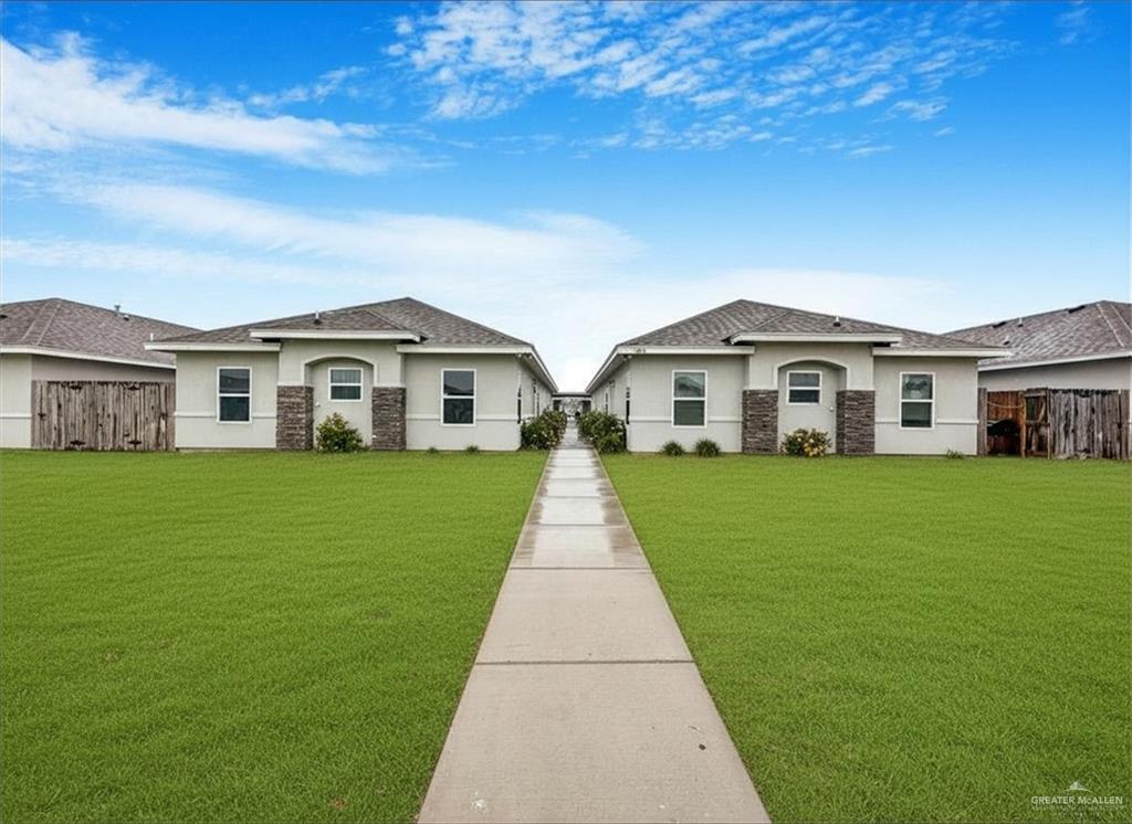 Duplex property featuring stucco exterior with stone veneer accents and a gabled roofline