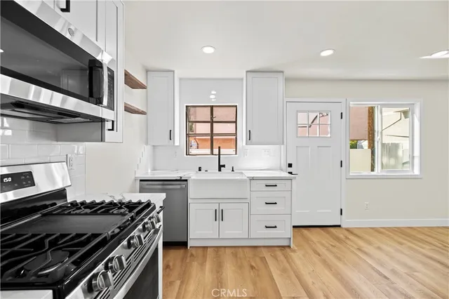 a kitchen with stainless steel appliances a stove microwave and cabinets