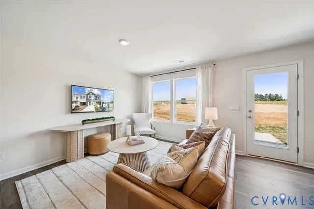 a living room with furniture a flat screen tv and a large window