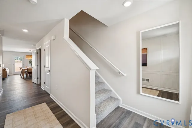 a view of a hallway with wooden floor and staircase