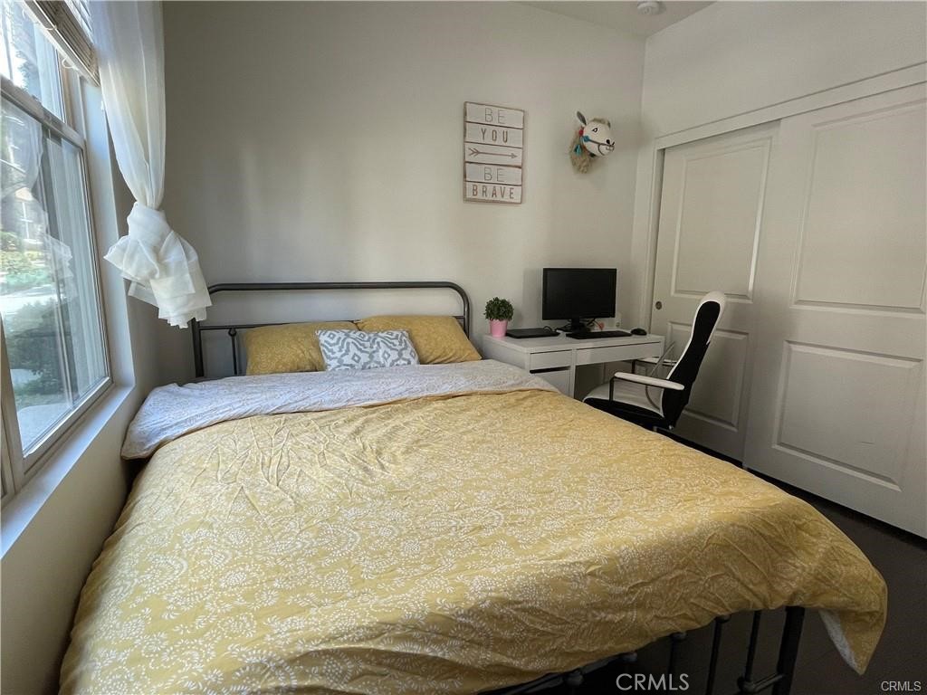 62 Emerald Clover Irvine, CA 92620 - Photo 8 of 15 a bed sitting in a bedroom next to a window with a tv and a mirror