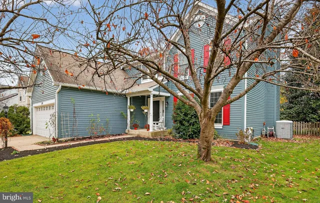 a front view of house with yard and trees in the background