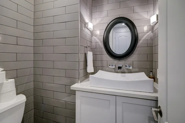 a bathroom with a sink a toilet and a mirror