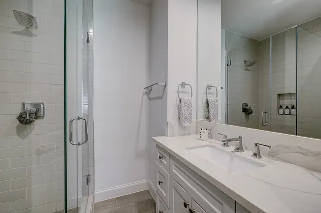 a bathroom with a granite countertop sink and a mirror