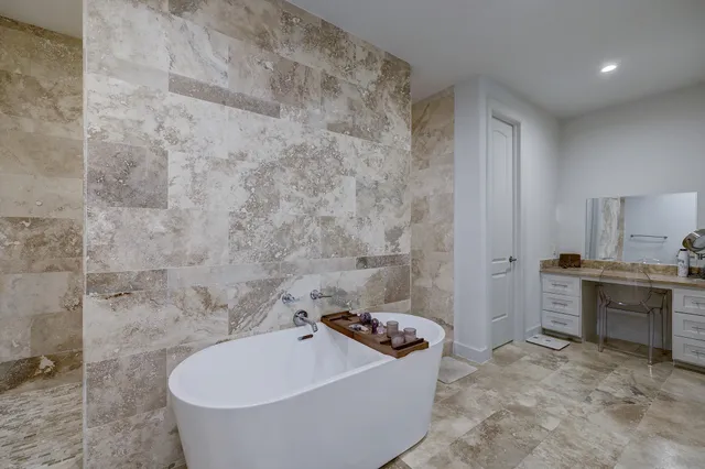 a bathroom with a tub sink toilet and mirror