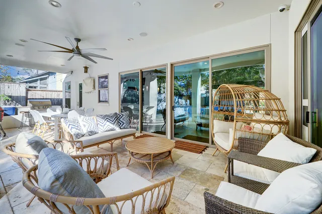 a living room with furniture a fireplace and a floor to ceiling window