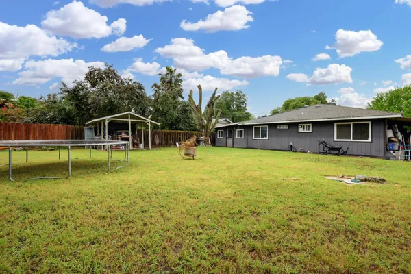 a view of a house with swimming pool and a yard