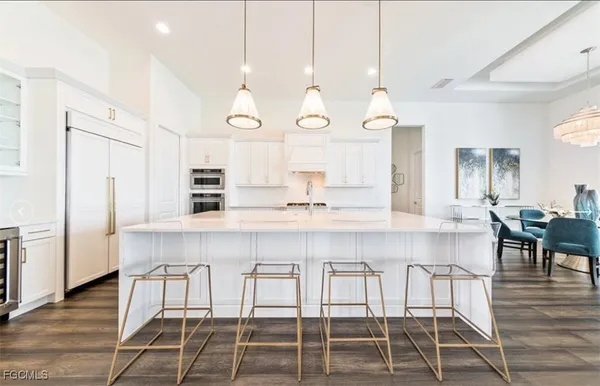 a kitchen with kitchen island granite countertop a table chairs sink and wooden floor