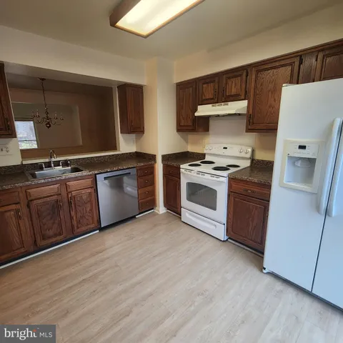 a kitchen with stainless steel appliances granite countertop a stove top oven and sink