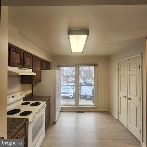 wooden kitchen with a stove and a refrigerator