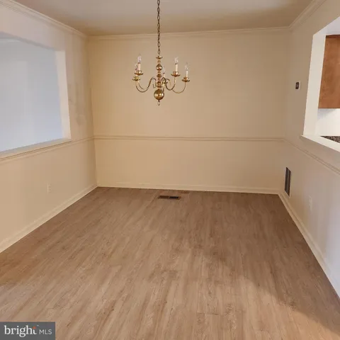 a view of a room with wooden floor and cabinets