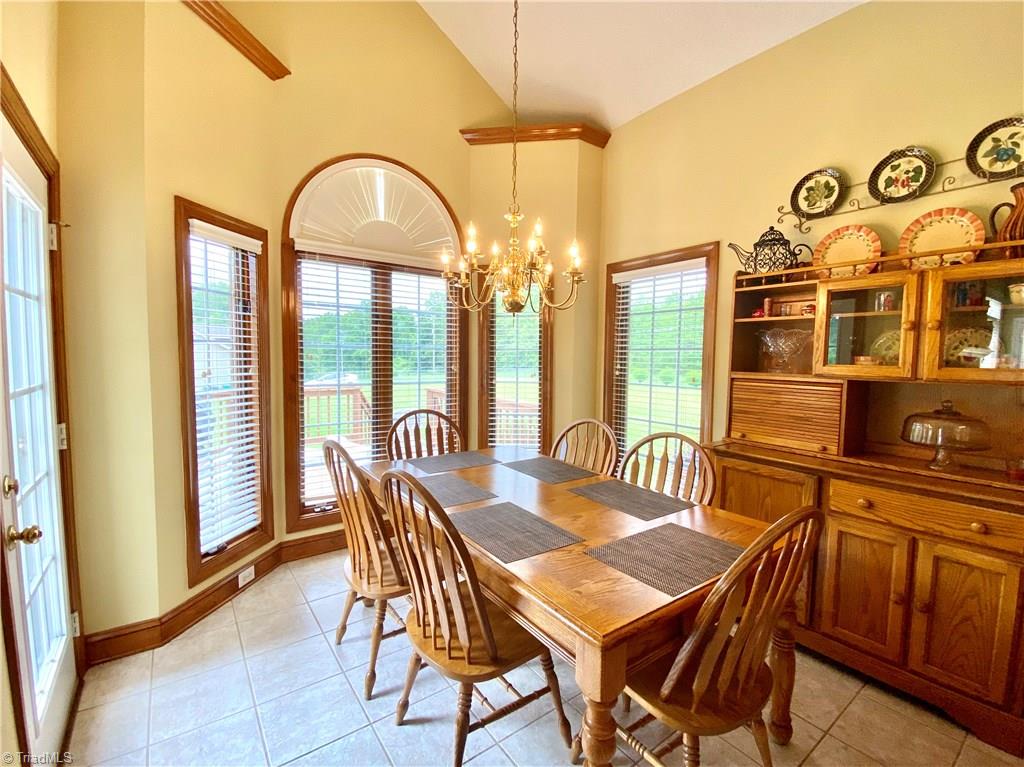 121 Belewsfield Road Stokesdale, NC 27357 - Photo 4 of 30 Breakfast area with vaulted ceiling. Exterior door leads to deck.