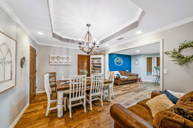 a living room with furniture a dining table and a chandelier