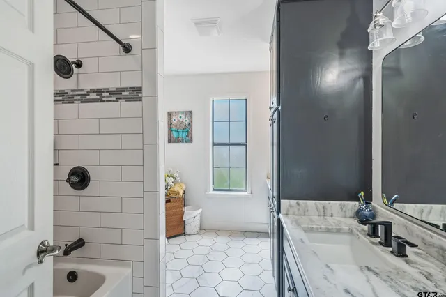 a bathroom with a granite countertop sink and a mirror