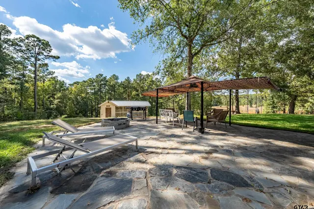a view of a patio with a table and chairs under an umbrella