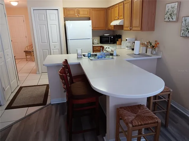 a kitchen with a table chairs and a refrigerator