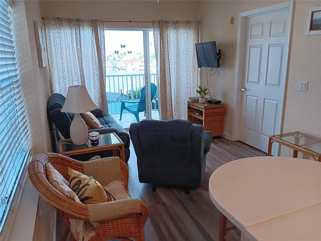 a living room with a couch and a potted plant next to a window