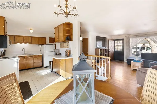 a living room with furniture a table and kitchen view