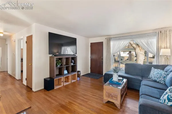 a view of a dining room with furniture a chandelier and wooden floor
