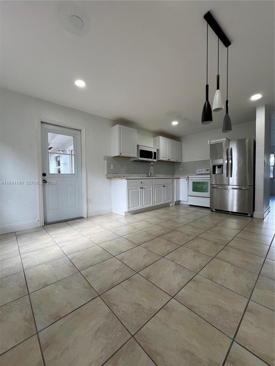 15400 Southwest 295th Street Homestead, FL 33033 - Photo 12 of 38 a kitchen with stainless steel appliances cabinets a sink and a stove