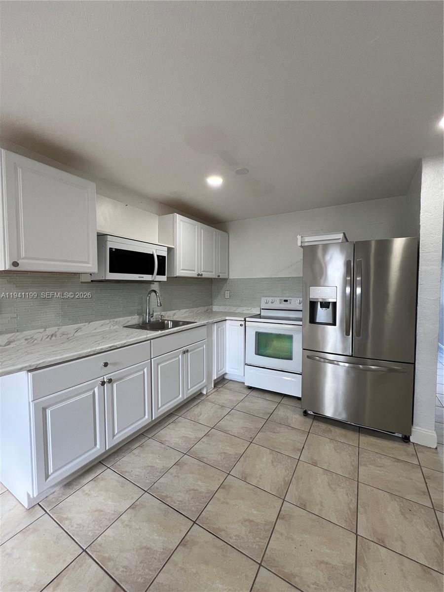 15400 Southwest 295th Street Homestead, FL 33033 - Photo 10 of 38 a kitchen with stainless steel appliances granite countertop a refrigerator and a stove top oven