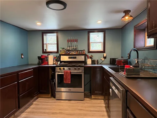a kitchen with kitchen island granite countertop a sink cabinets and stainless steel appliances