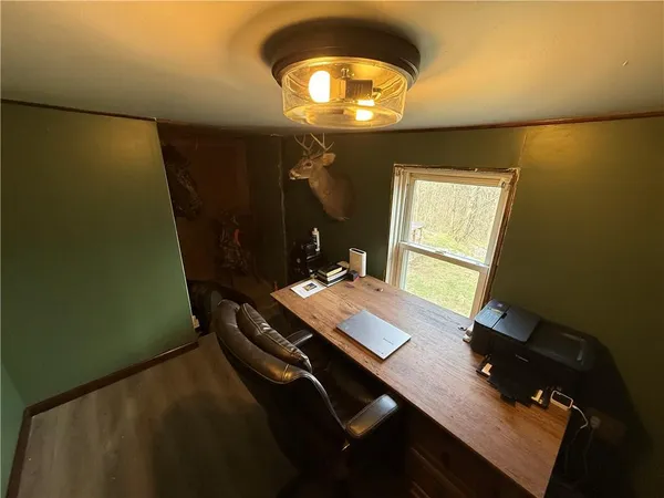 a view of a workspace with furniture and a window